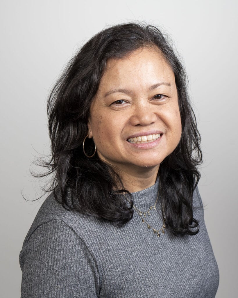 A woman with long black hair smiling.