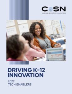 Driving K-12 Innovation: Tech Enablers 2022 report cover featuring diverse students happily learning in a classroom.