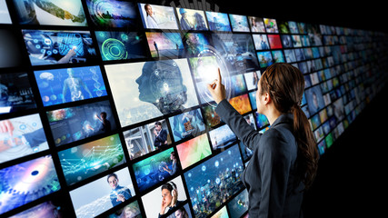 A woman views multiple computer screens.