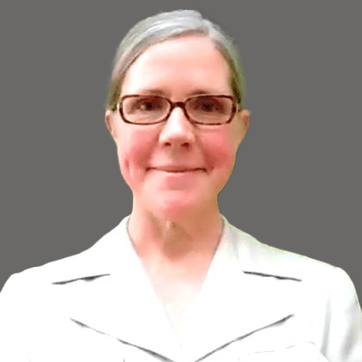 A profile photo of a blond woman with glasses smiling.